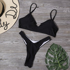 Black bikini top and thong-style bottom set, laid flat