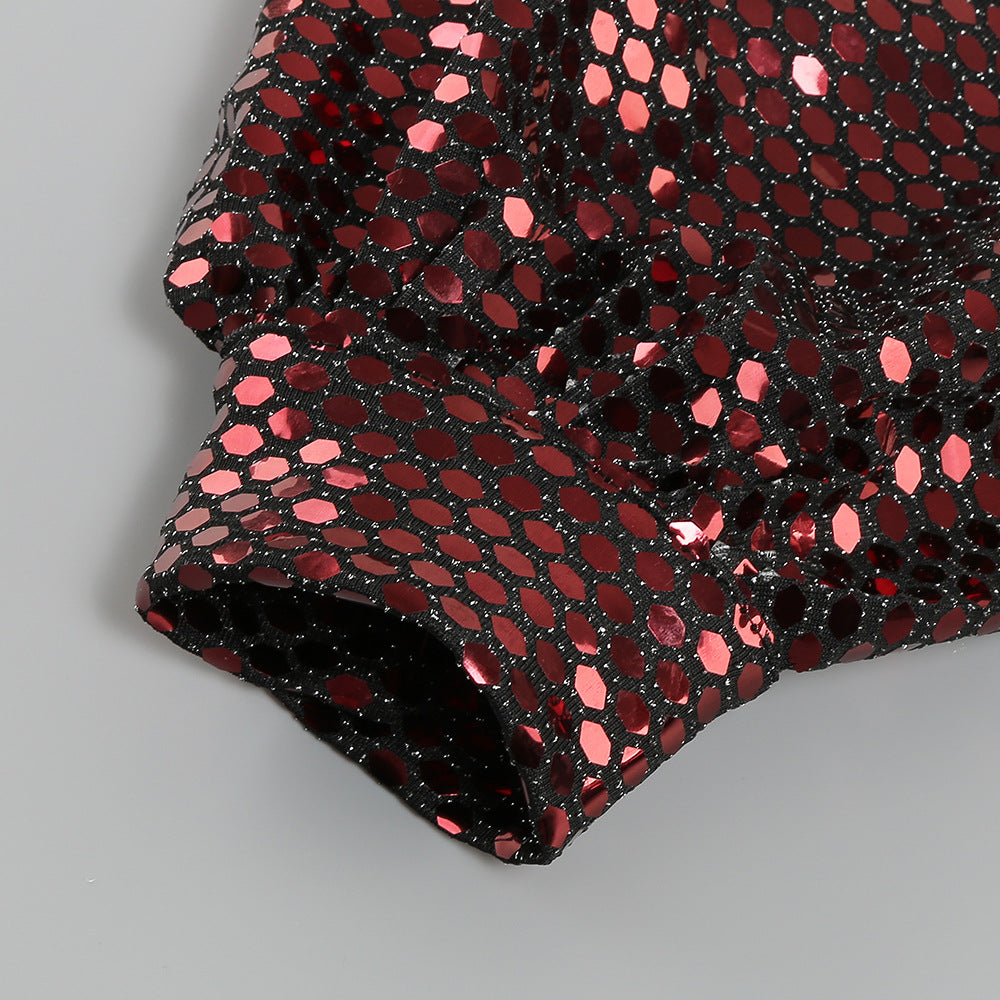 Close-up of sequin pattern on one-shoulder mini dress, folded fabric edge