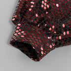 Close-up of sequin pattern on one-shoulder mini dress, folded fabric edge
