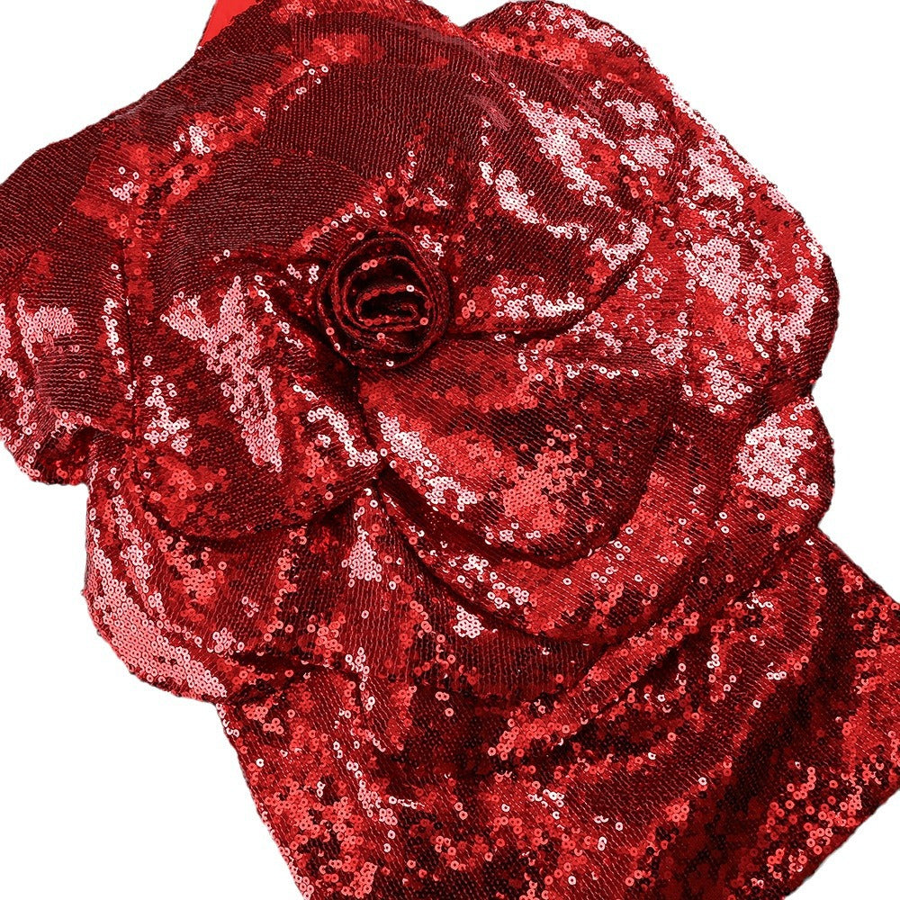 Close-up of red sequin fabric with rose applique on a fitted mini dress