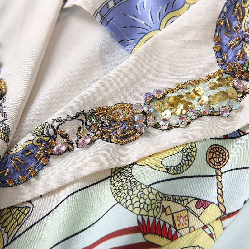 Sequin and bead-embellished neckline with gold trim on printed dress, multicolor accents.