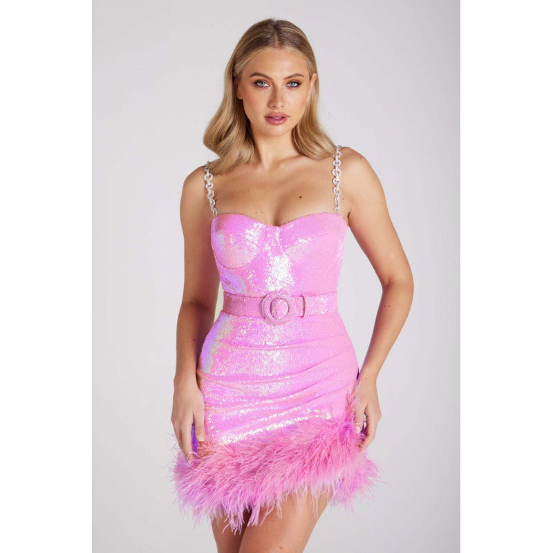 Pink sequin slip dress with sweetheart bodice, chain straps, and feathered mini hem