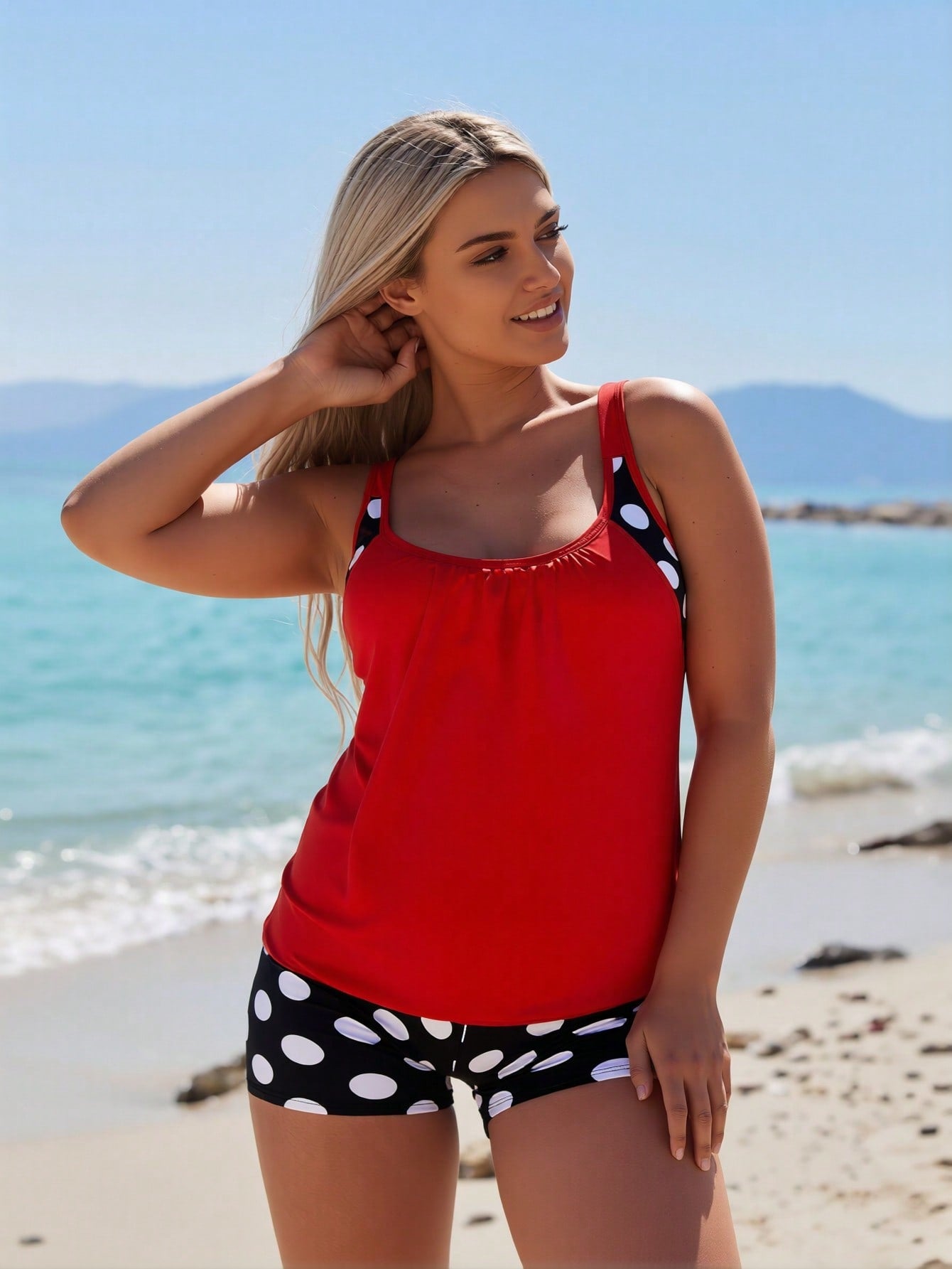 Red swimsuit tank with wide straps and scalloped neckline, paired with polka-dot shorts