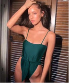 Green one-piece swimsuit with thin straps and ruched waist detail