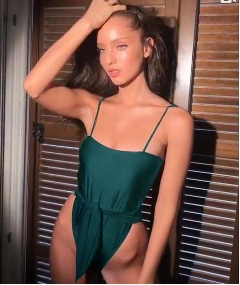 Green one-piece swimsuit with thin straps and ruched waist detail