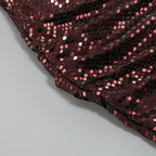 Close-up of rose gold sequin fabric on one-shoulder mini dress, textured sparkle