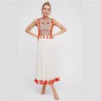 Women’s sleeveless floral dress with red patterned bodice, white skirt, red tassel hem.