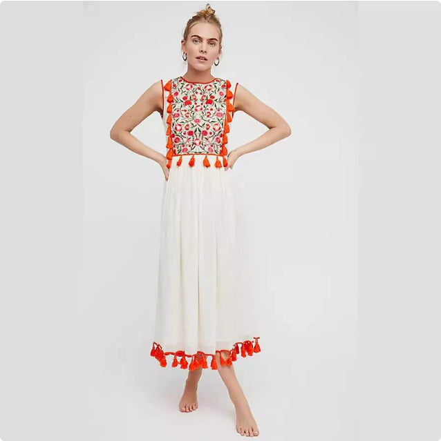 Women’s sleeveless floral dress with red patterned bodice, white skirt, red tassel hem.