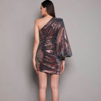 Rose gold sequin one-shoulder mini dress, back view with draped sleeve detail