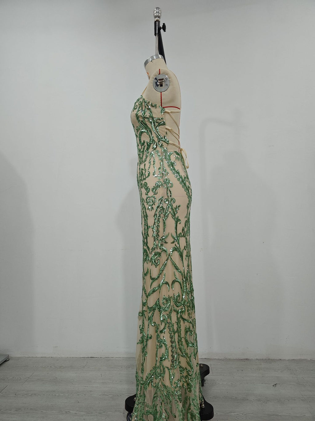 Women’s green sequin maxi dress on mannequin, side view, spaghetti straps, ornate pattern