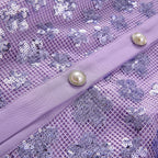 Lavender sequined fabric close-up with pearl-tone button tab on front belt strap