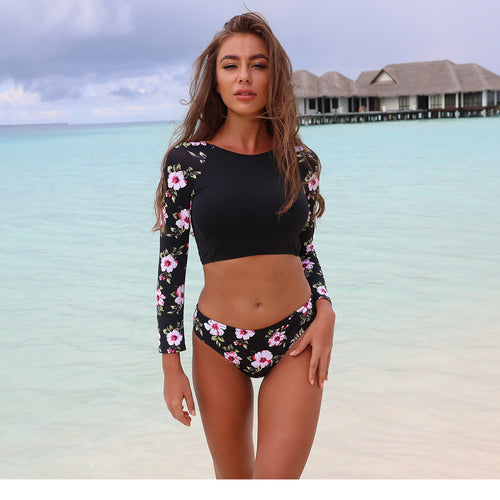 Backless swimwear set with floral print sleeves: black top and matching high-cut bottom.