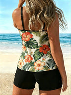 Tropical floral tankini with hibiscus print and black swim shorts, side view