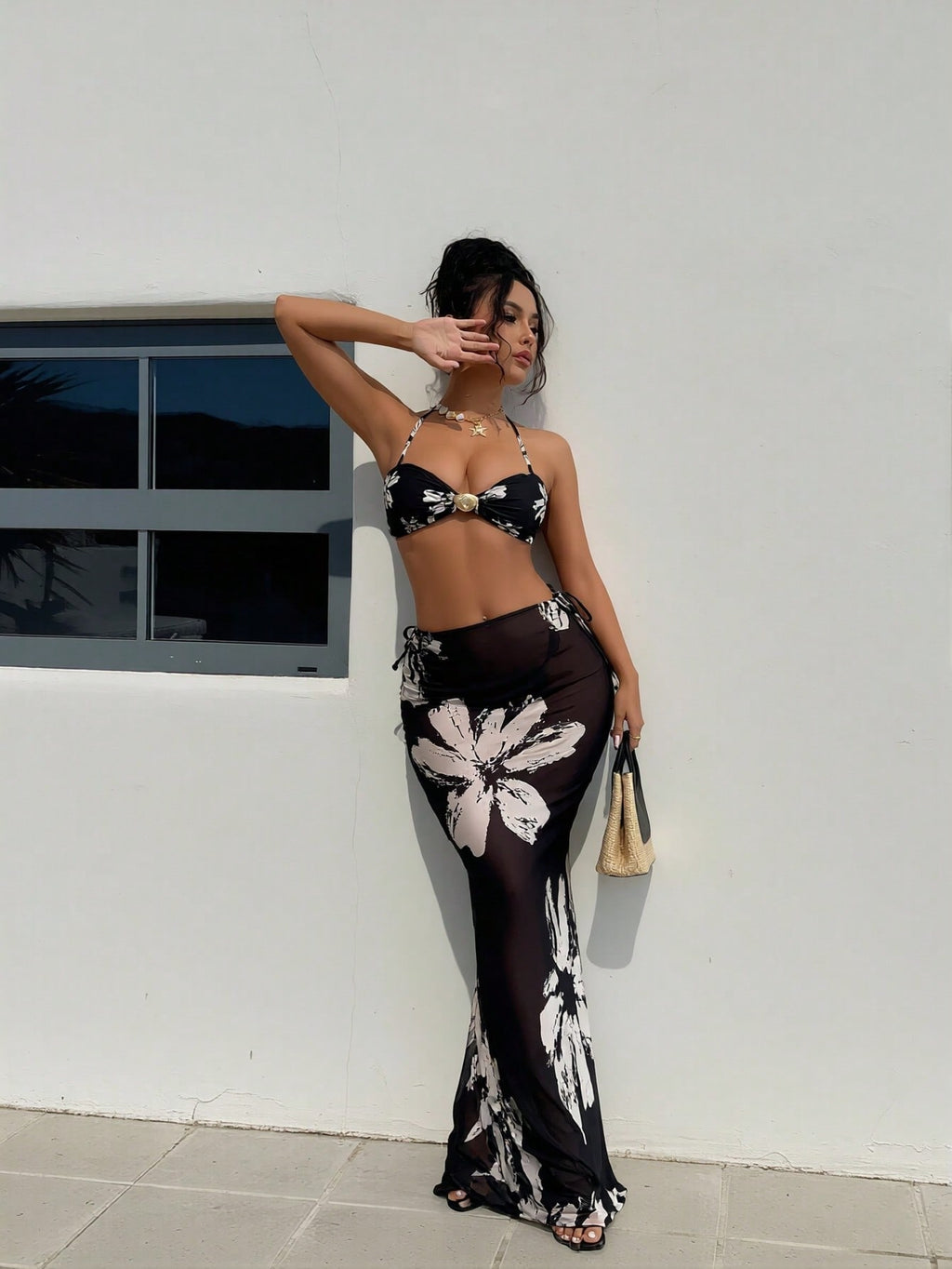 Black halter bikini with white floral print and matching long skirt, side view