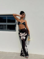 Black halter bikini with white floral print and matching long skirt, side view