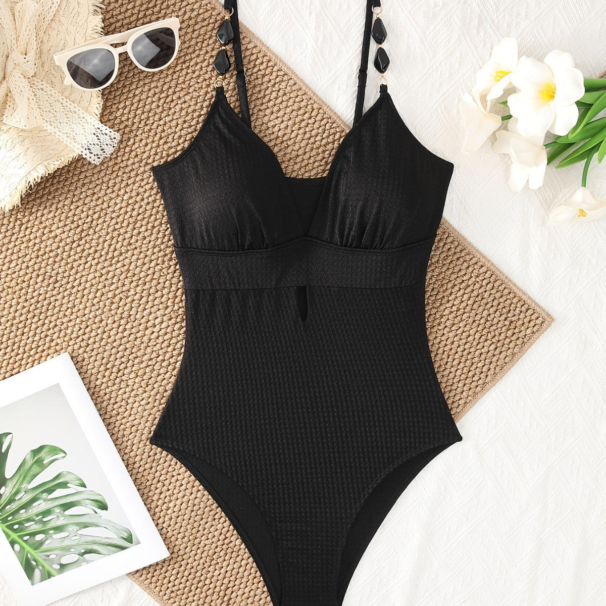 Black textured one-piece swimsuit with V neckline and adjustable spaghetti straps