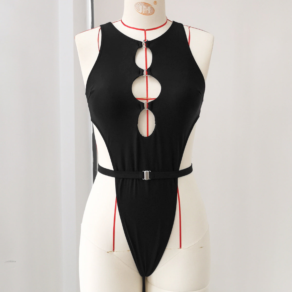 Black deep V one-piece swimsuit with vertical oval cutouts and waist belt.