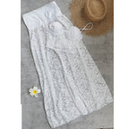 White lace two-piece bikini laid flat with ruffle-trim top and tied bottoms