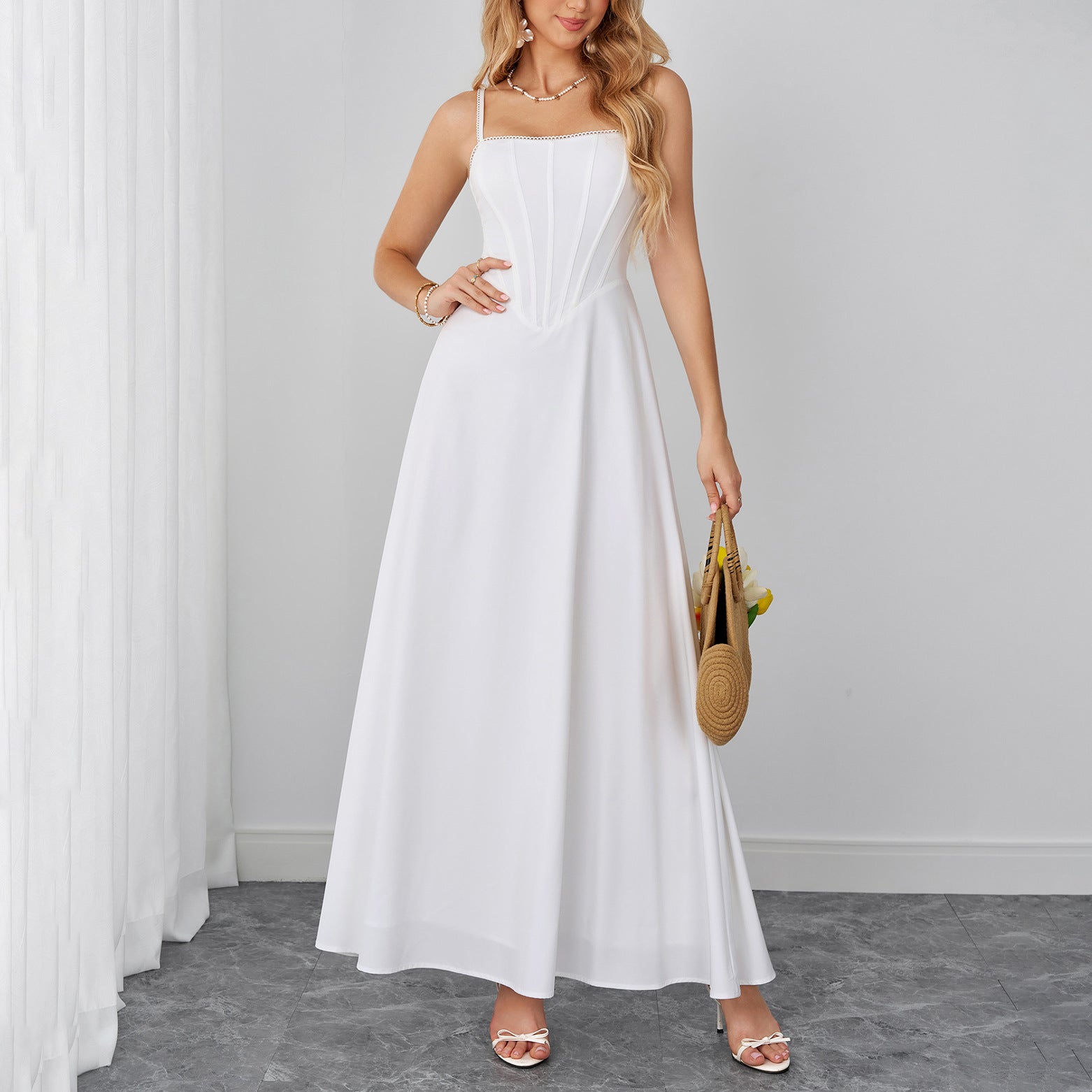 White sleeveless maxi dress with spaghetti straps and sweetheart neckline.