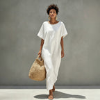 White mini shift dress with short sleeves and round neckline, draped front hem