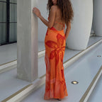 Orange lace maxi dress with open back, thin straps and floral lace pattern