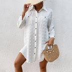 White textured button-up swim cover-up tunic with long sleeves, worn over dark one-piece