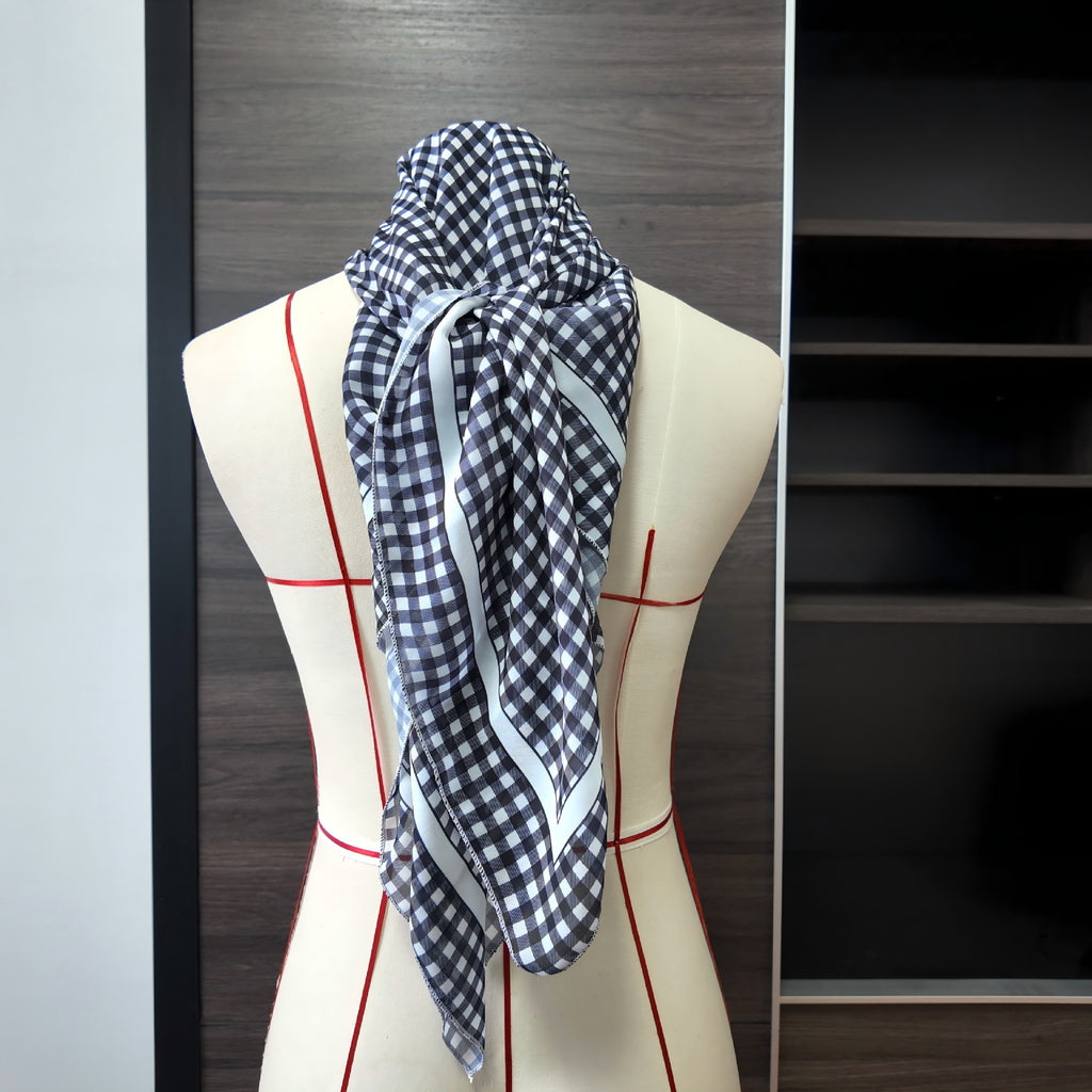 Black-and-white plaid one-piece swimwear with matching scarf draped