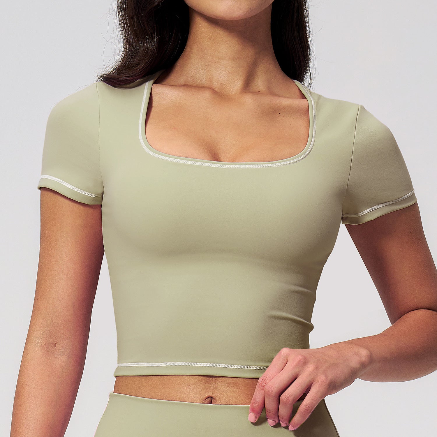 Light green cropped sports top with contrast trim and short sleeves