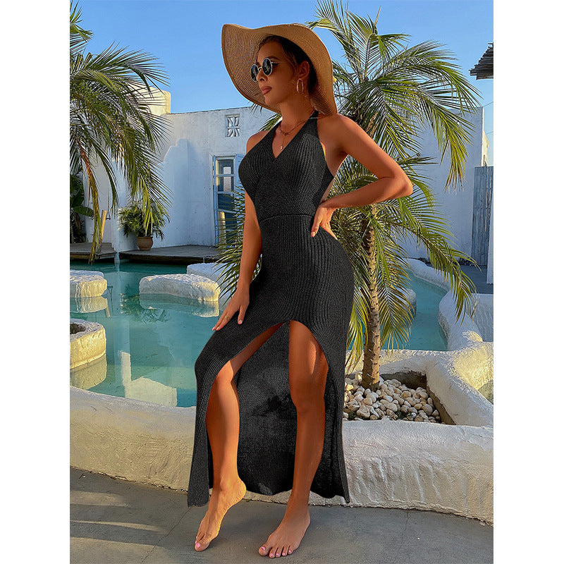 Backless halter maxi dress in black with open back and long skirt with side slit.