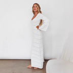 White maxi knit dress, long sleeves, V-neck, textured horizontal stitch lines.