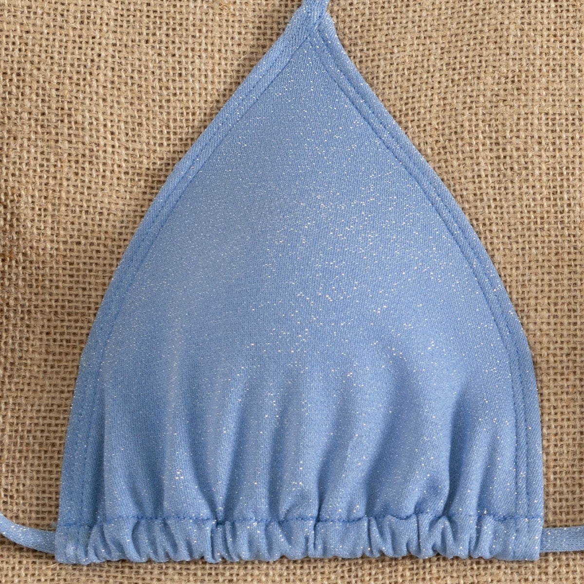 Blue triangle bikini top with ruffled edge and halter tie straps, textured fabric