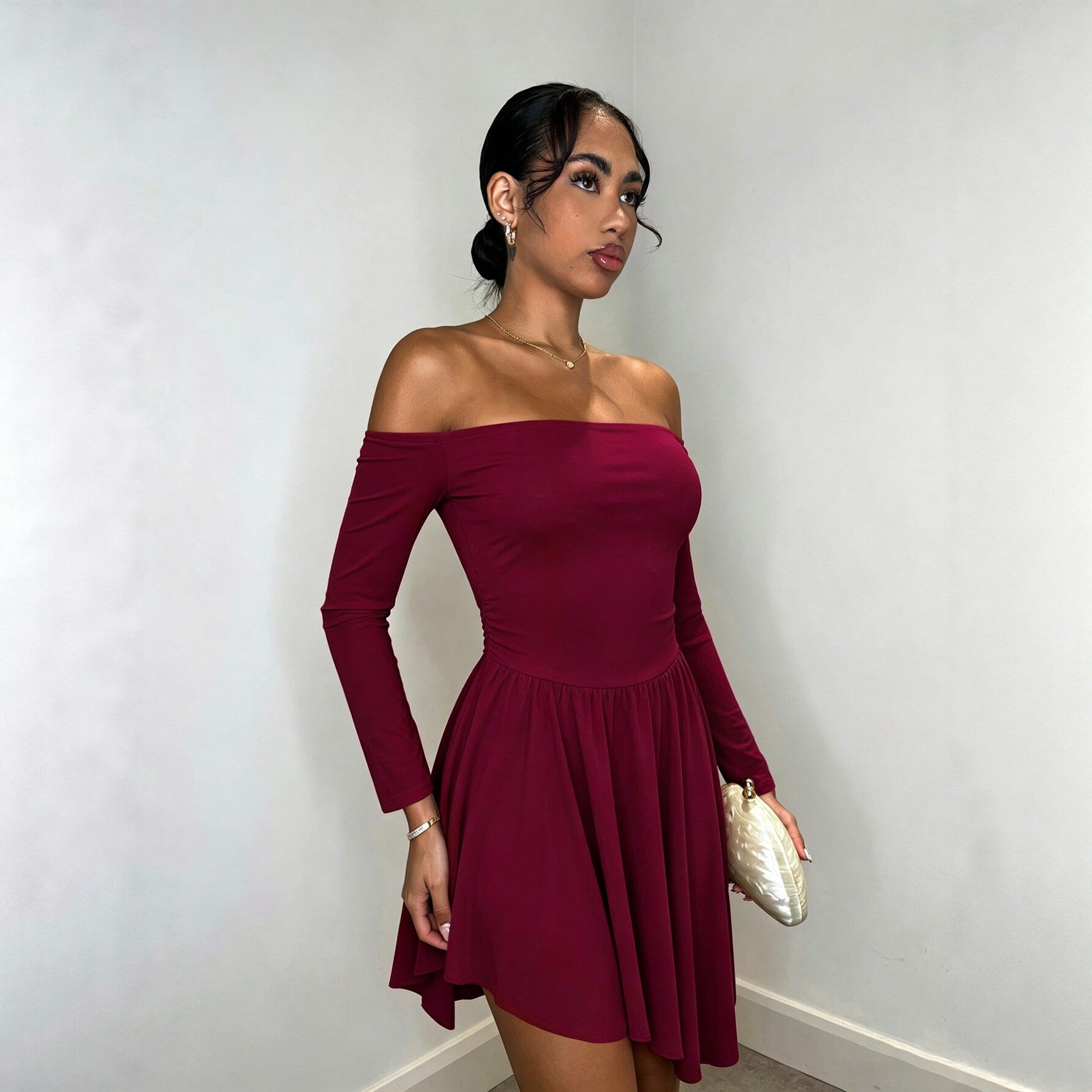 Burgundy long-sleeve off-shoulder dress with gathered waist and flowing pleated hem