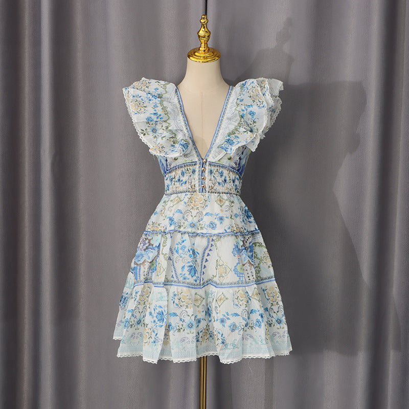 Blue-and-white floral sundress with deep V-neck, ruffled sleeves, and tiered lace hem