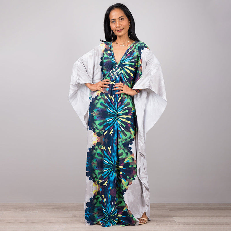 One-piece beach swim dress with V-neck and draped sleeves, white with blue-green flower print