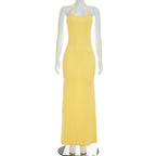 Yellow backless maxi dress on mannequin with spaghetti straps and scoop neckline.