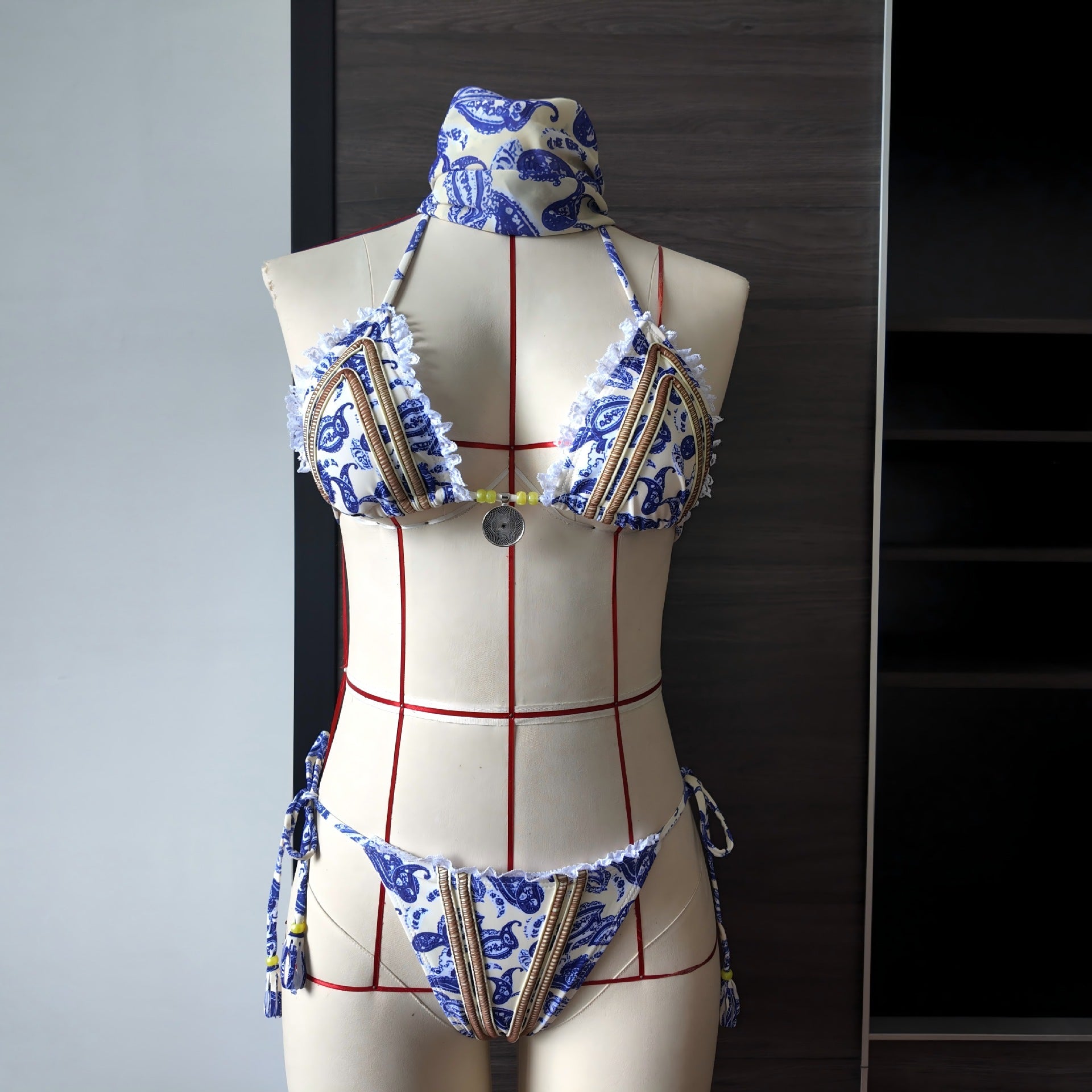 Printed lace bikini set on mannequin: triangle top and tie-side bottoms, blue pattern with red