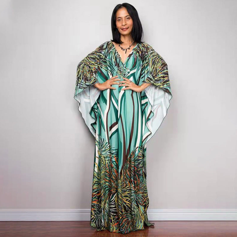 One-piece beach dress with teal and green palm-feather print and V-neck drape