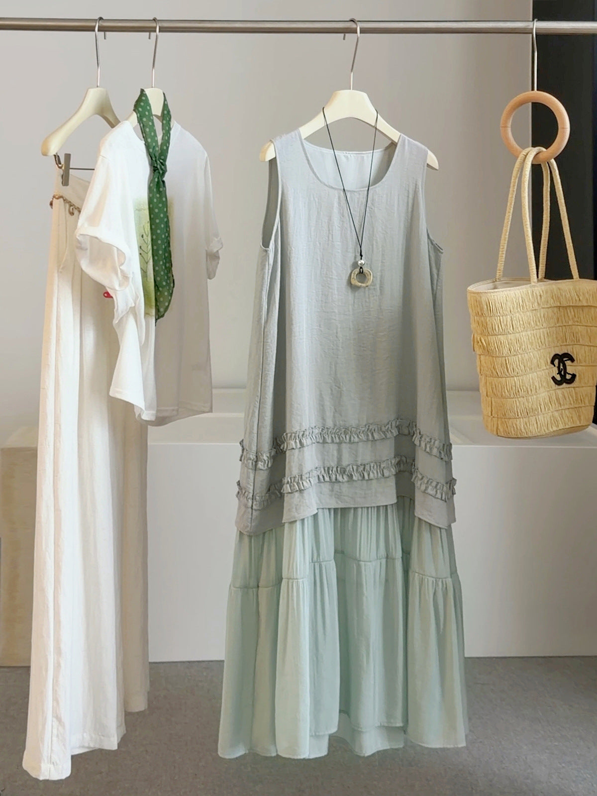 Gray-green sleeveless summer dress with lace-trimmed hem and tiered skirt