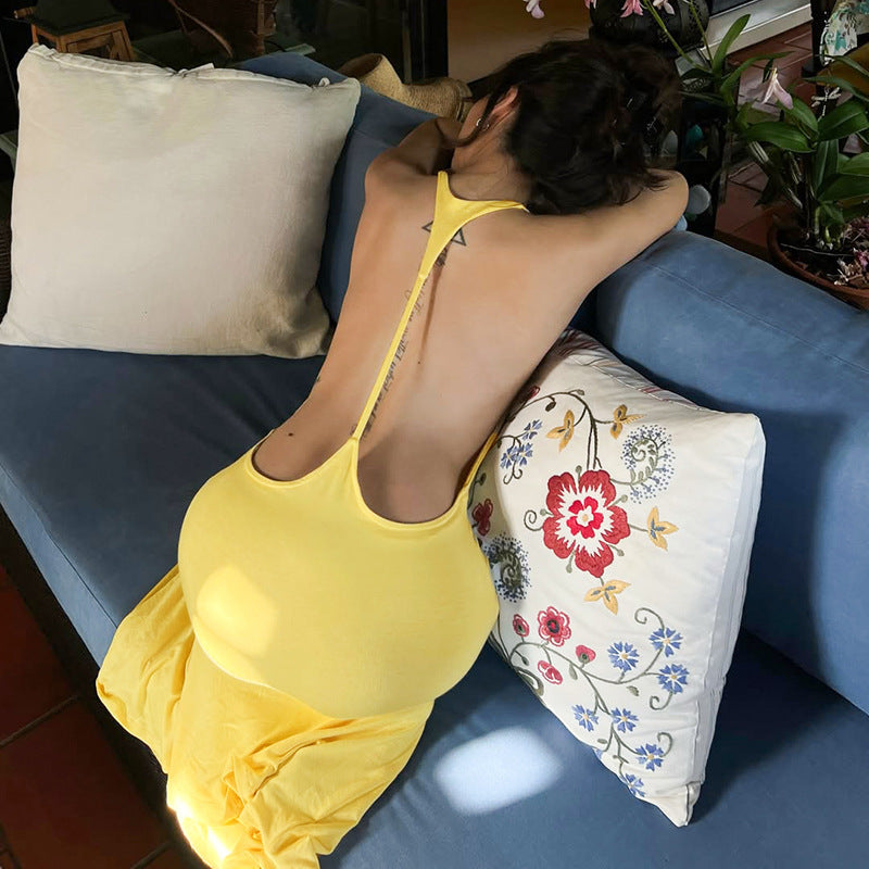 Yellow backless maxi dress close-up with thin straps and open back.