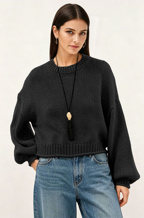 Black knit crew-neck pullover sweater with ribbed cuffs and tassel cord
