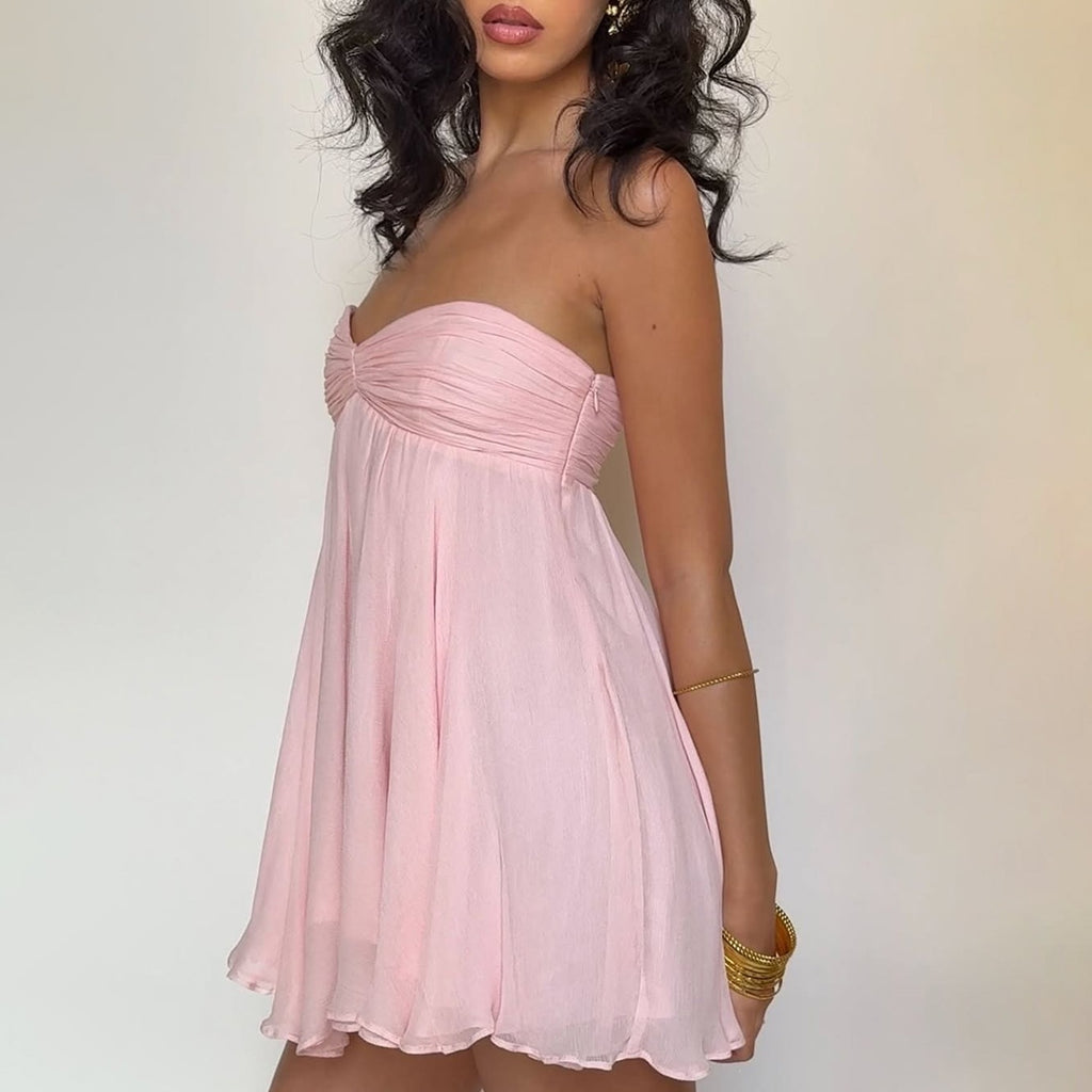 Pink strapless mini summer dress with gathered bust and flowing pleated skirt