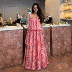 Women's halter tiered maxi dress in coral pink with abstract swirl pattern