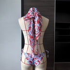 Printed lace bikini set with draped headscarf on mannequin, back view, blue-and-red pattern