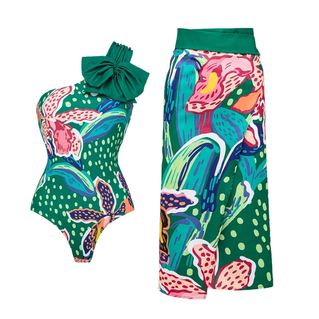 Green one-piece swimsuit with abstract fruit print and large bow; wrap skirt included