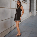 Black sleeveless mini dress with button front and scalloped trim hem