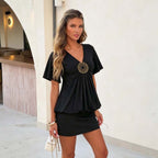 Women's black pleated short-sleeve dress with V-neck and decorative circular chest ornament
