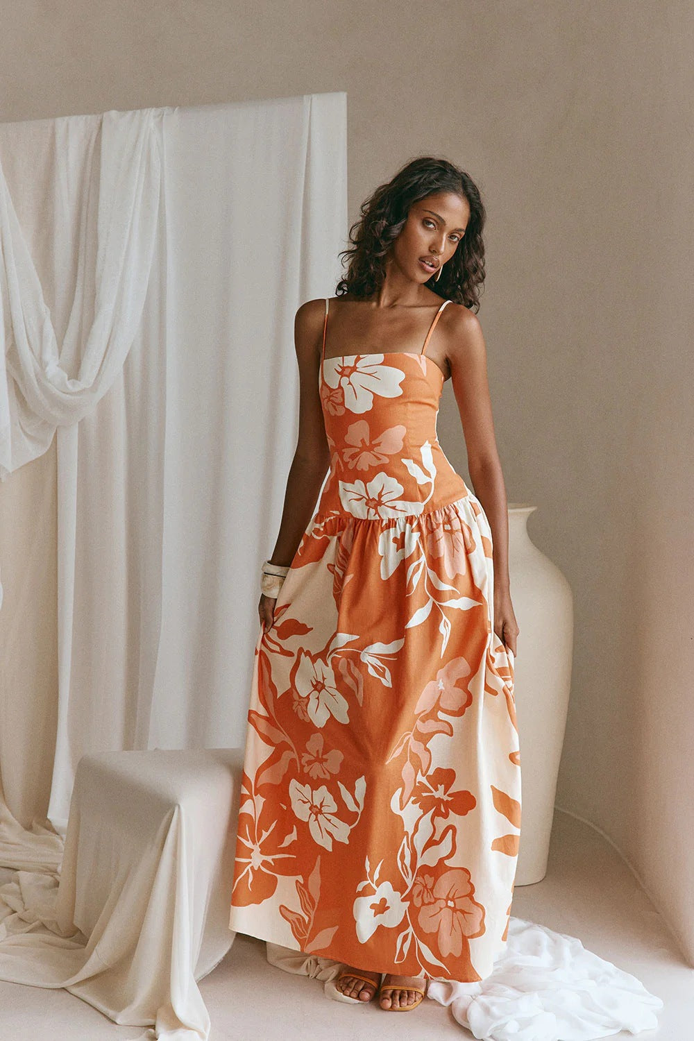 Orange and white floral maxi dress with spaghetti straps and flowing gathered skirt