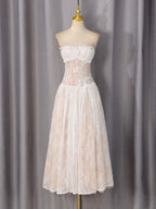 White lace dress on mannequin, ruffled off-shoulder bust and tiered skirt