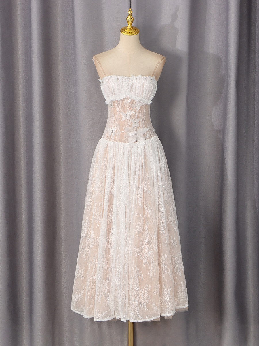 White lace dress on mannequin, ruffled off-shoulder bust and tiered skirt