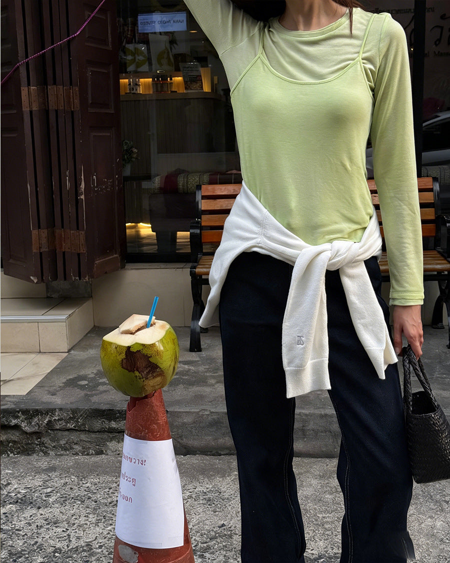 Light green long-sleeve top with faux camisole overlay and side tie hem detail